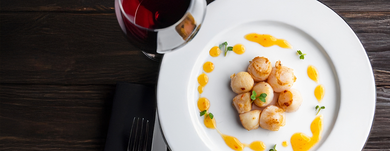 place setting with forks and knifes, menu and wine glasses